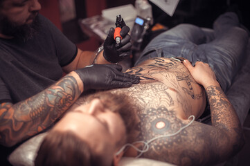 Tattoo specialist works in tattoo studio