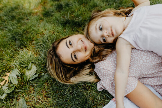 Young Mom and Daughter Laying in Grass