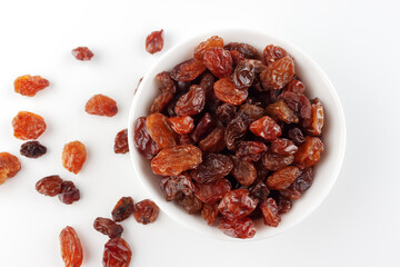 White bowl with raisins on a white background and space for text, top view.