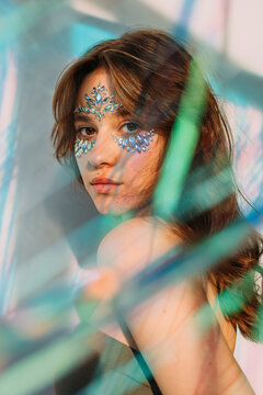 Lovely teenager with stylish make up among tinsel