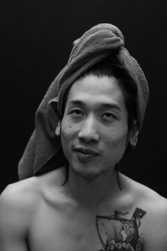 smiling man with shower towel on his head.
