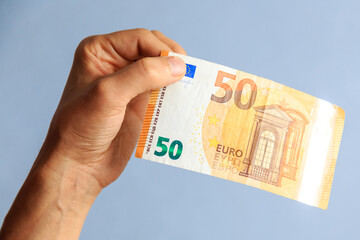 the hand holds 50 euro bill