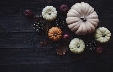Obraz na płótnie Canvas Autumn Halloween background with pumpkins on a dark rustic wooden board - top view