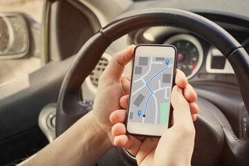 driver using direction navigation on GPS map on the screen of mobile smartphone in the car