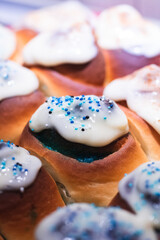 Cinnamon Rolls o Rollitos de Canela caseros, hechos en casa, rellenos con azúcar de color azul y cubiertos por una capa de glaseado con unas bolitas de azúcar de color azul por encima