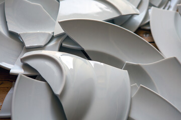 pile of broken white plates shattered on floor