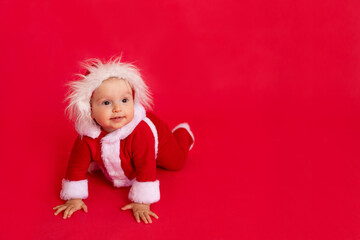 child on a red background in a Santa suit, the concept of new year and Christmas, place for text