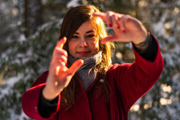 Obraz premium Winter snow portrait of an European woman breath condensation with red cloth in a tranquil forest background