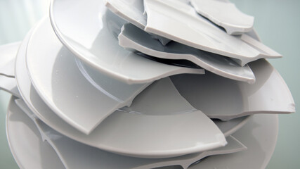 pile of broken white plates on glass table