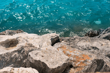 Fantastic rocky shore of the sea, stone coast, natural sea background incredible color of water.
