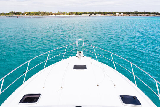 The bow of a luxury yacht sitting in clean clear turquoise ocean waters off the coast of Perth