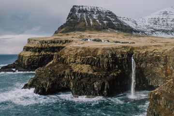 View of Mularfossur waterfall and small village in winter