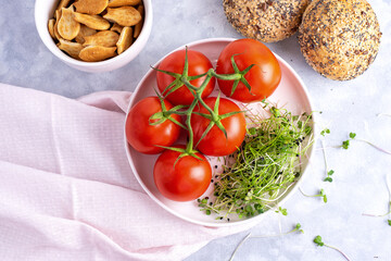 microgreens with tomatoes  on a white plate and white plate with cookies and cereal buns