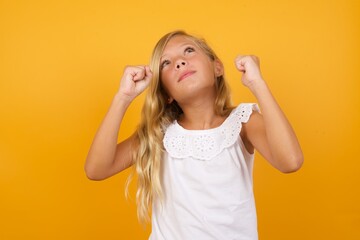 Beautiful Caucasian young girl standing against yellow background having success being glad to achieve his goals. Victory and triumph concept.