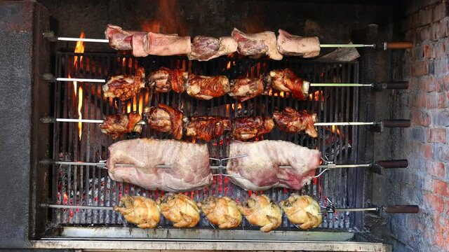 Pollo arrosto, puntine, stinco sul grill, che gira sul fuoco nel ristorante