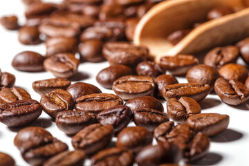 Freshly roasted coffee beans background.Dark roasted coffee beans with scoop on wooden background.
