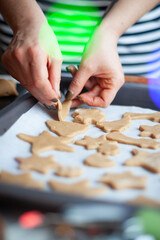 Preparation of ginger biscuits. A woman cuts out cookies as a star shape. Pastry cooking, homemade cuisine concept.