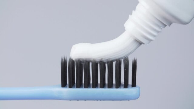 Shooting of toothpaste on toothbrush on white background