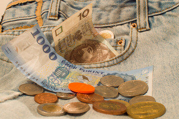 Banknotes and coins from different countries on denim: Polish zlotys, Hungarian forint, Moroccan...