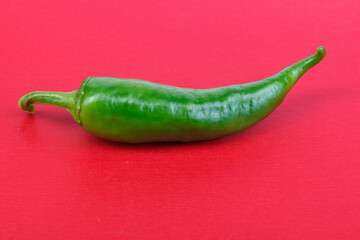 Green chili paprika, on a red background. Healthy food. Fresh vegetables. Green chili Peppers on a white background. Close-up.