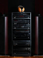 Audio-video equipment in rack at dark background