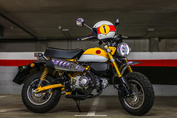 Fototapeta premium Disparo horizontal de una moto clásica color amarillo con un casco en el manillar