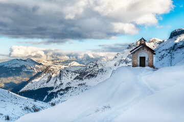 Winter day over the snow covered mountains and small chapel