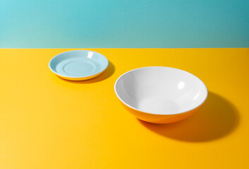 Set of a tea plate and a deep plate on colorful background with copy space
