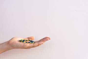Fototapeta premium Wrist bracelet on woman's palm on the white background with copy space for text. Symbol of Ukraine on hand bracelet.with blue and yellow colors Dedication to culture of Ukraine