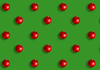 Seamless pattern from large red Christmas balls on a green background. Flat lay