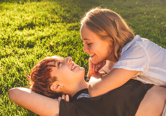 Girls couple in love lying on the grass in a park on a sunny day.