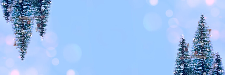 Trendy Christmas banner background - Christmas tree or New Year tree with decorations and bokeh lights on trendy blue background with copyspace for your text. Selective focus, place for text