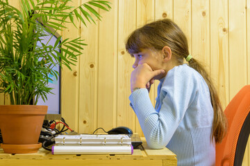 The girl thought hard while solving a problem in the computer