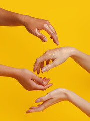Fresh honey pour on women's hands. Yellow background