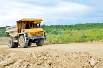 Mining truck and excavators working in the limestone open-pit. Loading and transportation of minerals in the dolomite mining quarry