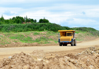 Obraz premium Mining truck working in the limestone open-pit. Loading and transportation of minerals in the dolomite mining quarry