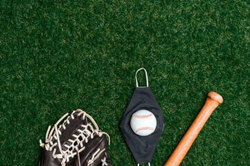 Baseball bat, ball, glove and mask isolated on a field of grass. Baseball season with face mask. Safe sport concept