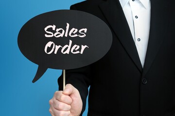 Sales Order. Businessman holds speech bubble in his hand. Handwritten Word/Text on sign.