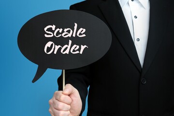 Scale Order. Businessman holds speech bubble in his hand. Handwritten Word/Text on sign.