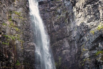 Waterfall falling from high rocks in Fulufjallet Nature Reserve
