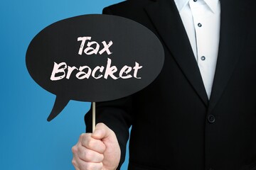 Tax Bracket. Businessman holds speech bubble in his hand. Handwritten Word/Text on sign.