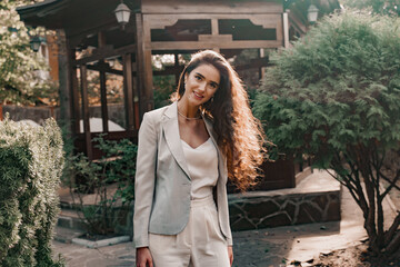 Smiley girl in the green park. Happy young woman walks around green garden. Lifestyle of young business woman.