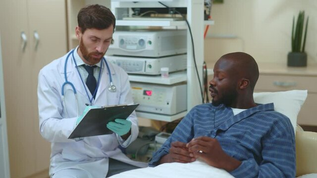 African american adult patient having conversation with general practitioner doctor about pills medicine prescription healthcare talking in hospital room medical office.