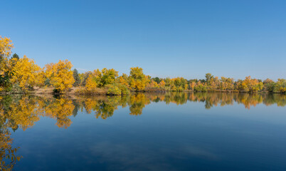 Colorful Fall Trees Wrapping Around Lake with Reflections in Water