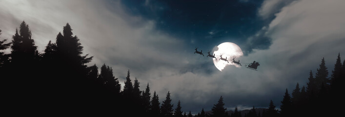 Panoramic - Santa Claus flying over pine trees in his sleigh under the moonlight