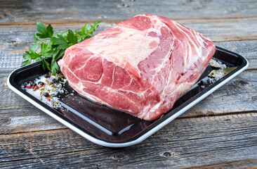 Traditioneller roher Schmorbraten vom Schwein mit Kräuter angeboten als close-up auf einem...
