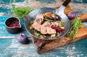 Traditional cooked sliced veal tongue figs and cranberries offered as close-up in a rustic...