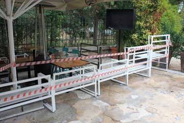 Greece, Athens, November 3 2020 - Chairs, tables and other furniture stacked outside closed cafe-restaurant around Acropolis hill, after the announcement for Covid-19 lockdown.