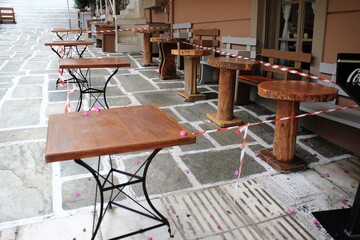 Greece, Athens, November 3 2020 - Chairs, tables and other furniture stacked outside closed cafe-restaurant around Acropolis hill, after the announcement for Covid-19 lockdown.