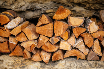 Pile of firewood in storage in the open air, countryside, firewood background, chopped firewood on a stack. Preparation for winter.